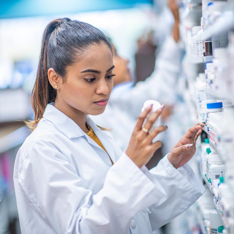 Pharmacist reading bottle of generic drugs